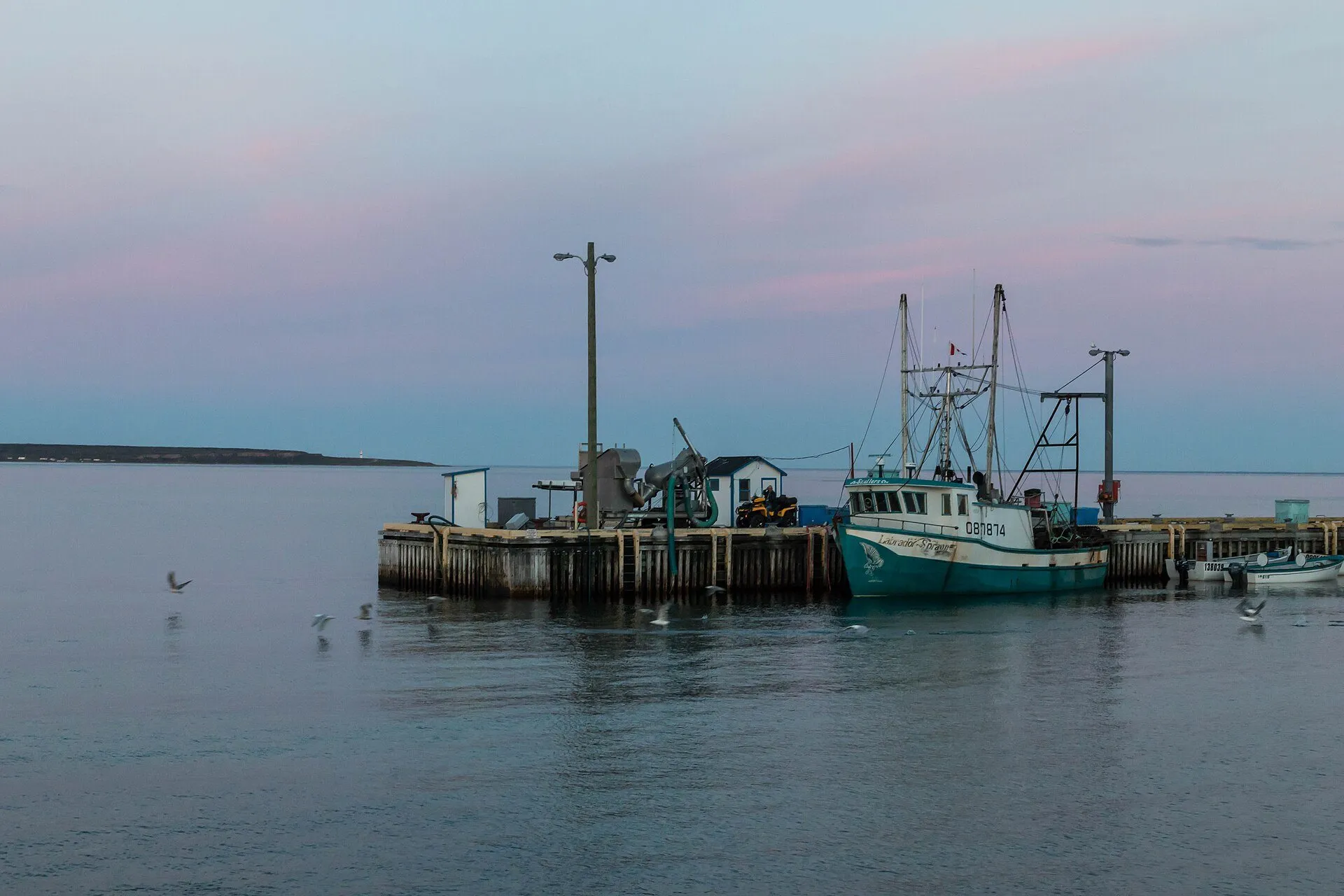 The wharf at Forteau with fishing boats tied up, on a calm evening on the Strait of Belle Isle.