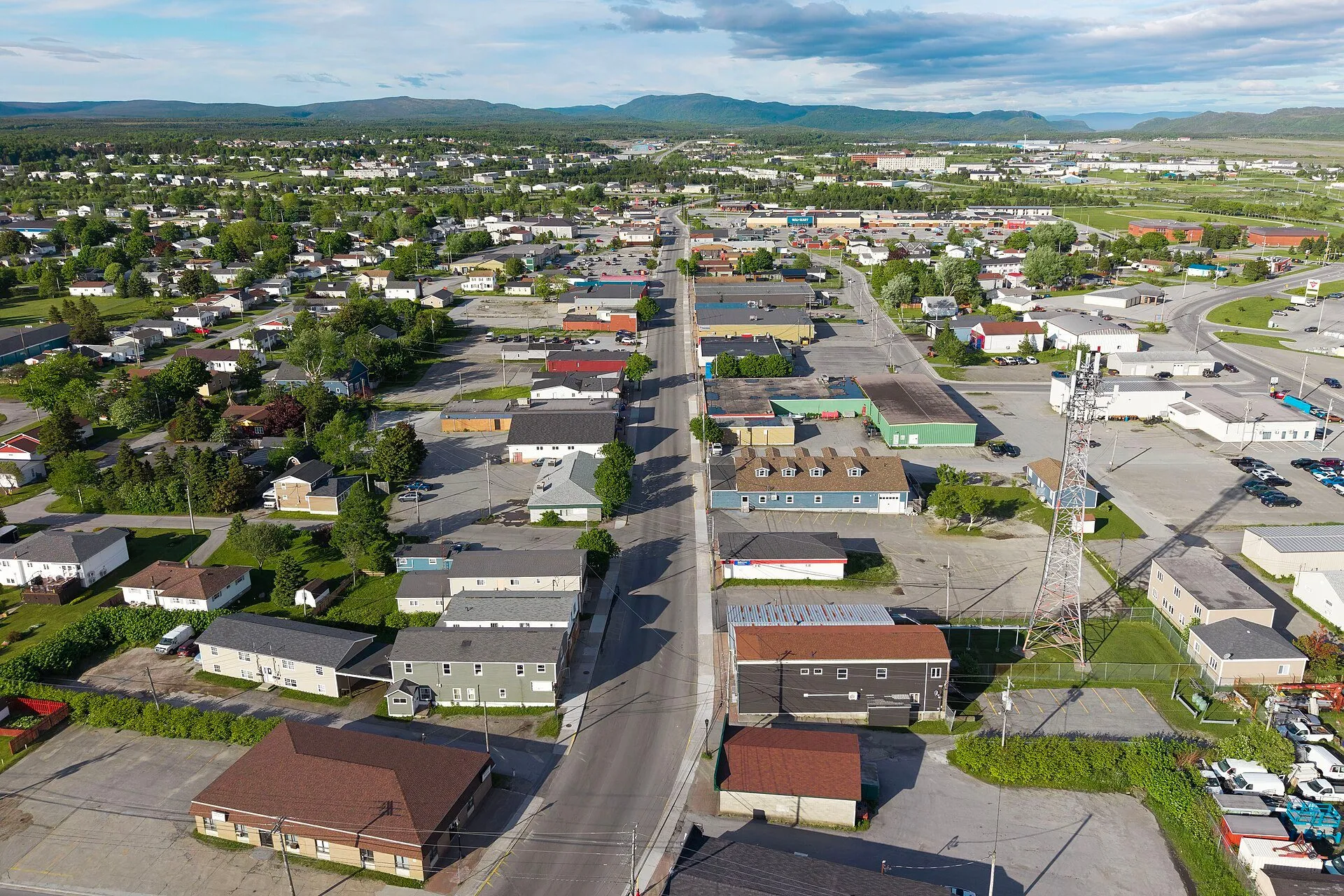 Aerial view over Stephenville's low-rise streets and buildings, with forested hills along the horizon.